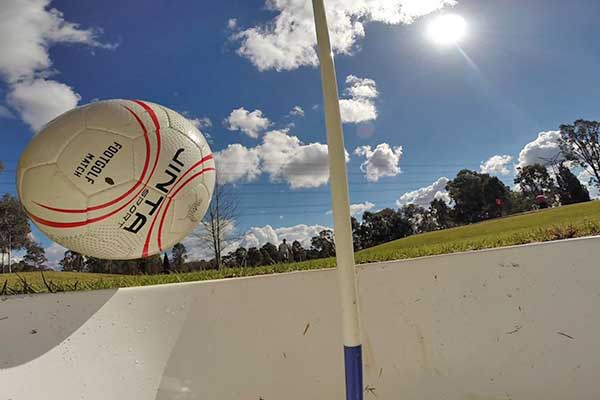 Football bouncing into a hole on the course