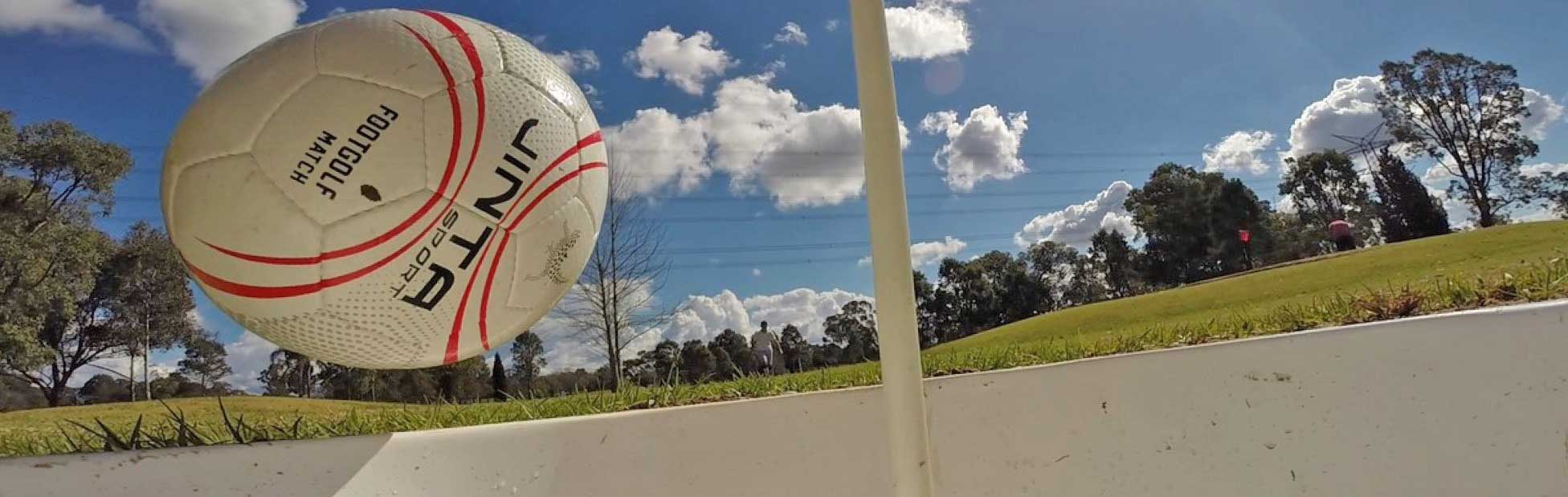 Football bouncing into a hole on the course