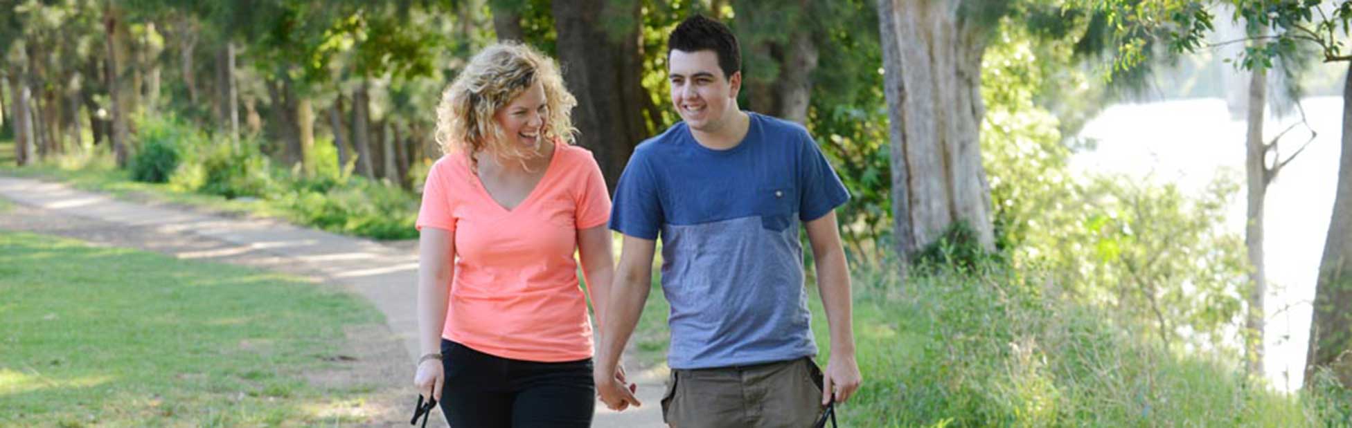 Young couple walking their dogs along the Great Nepean River Walk footpath